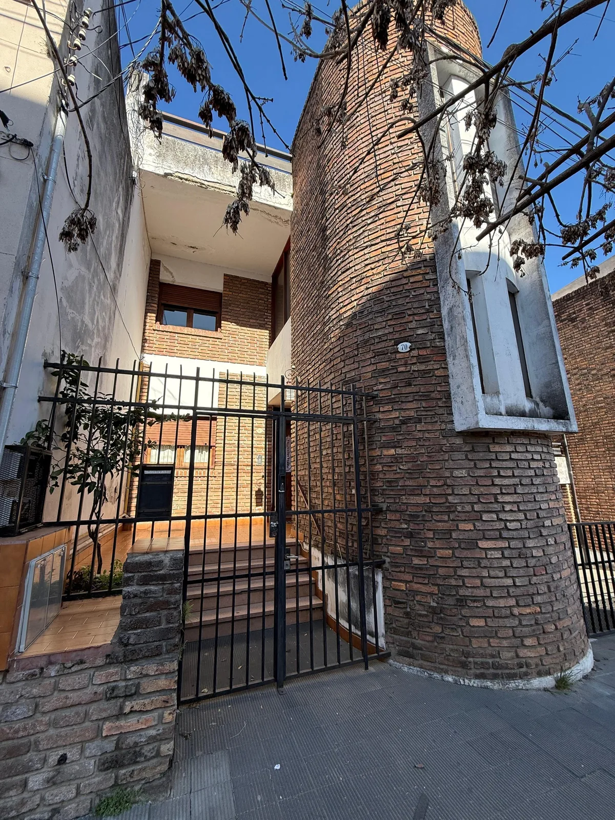 El ingreso, con reja y escalones hasta la puerta
