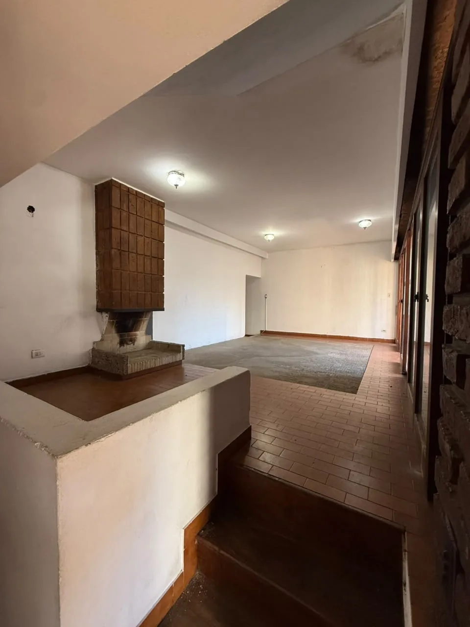 El living, con hogar y ventanales al balcón