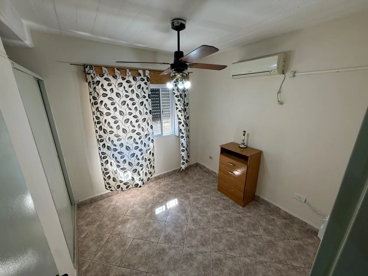 El segundo dormitorio, con aire acondicionado, ventilador de techo y placard de puertas corredizas