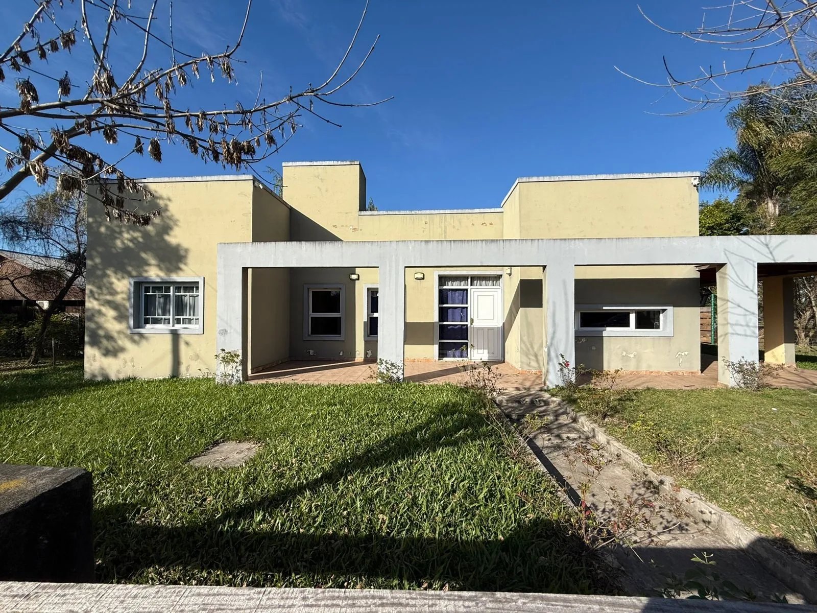 Frente de la casa en Puerto Yeruá, con galería y jardín
