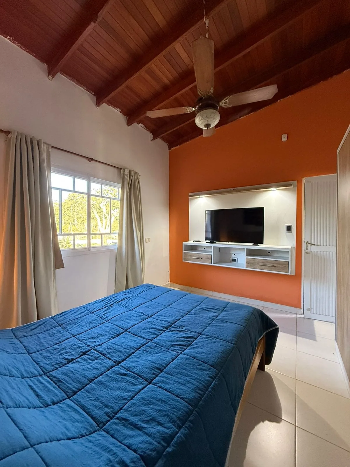 Dormitorio principal, con techo de madera y ventana