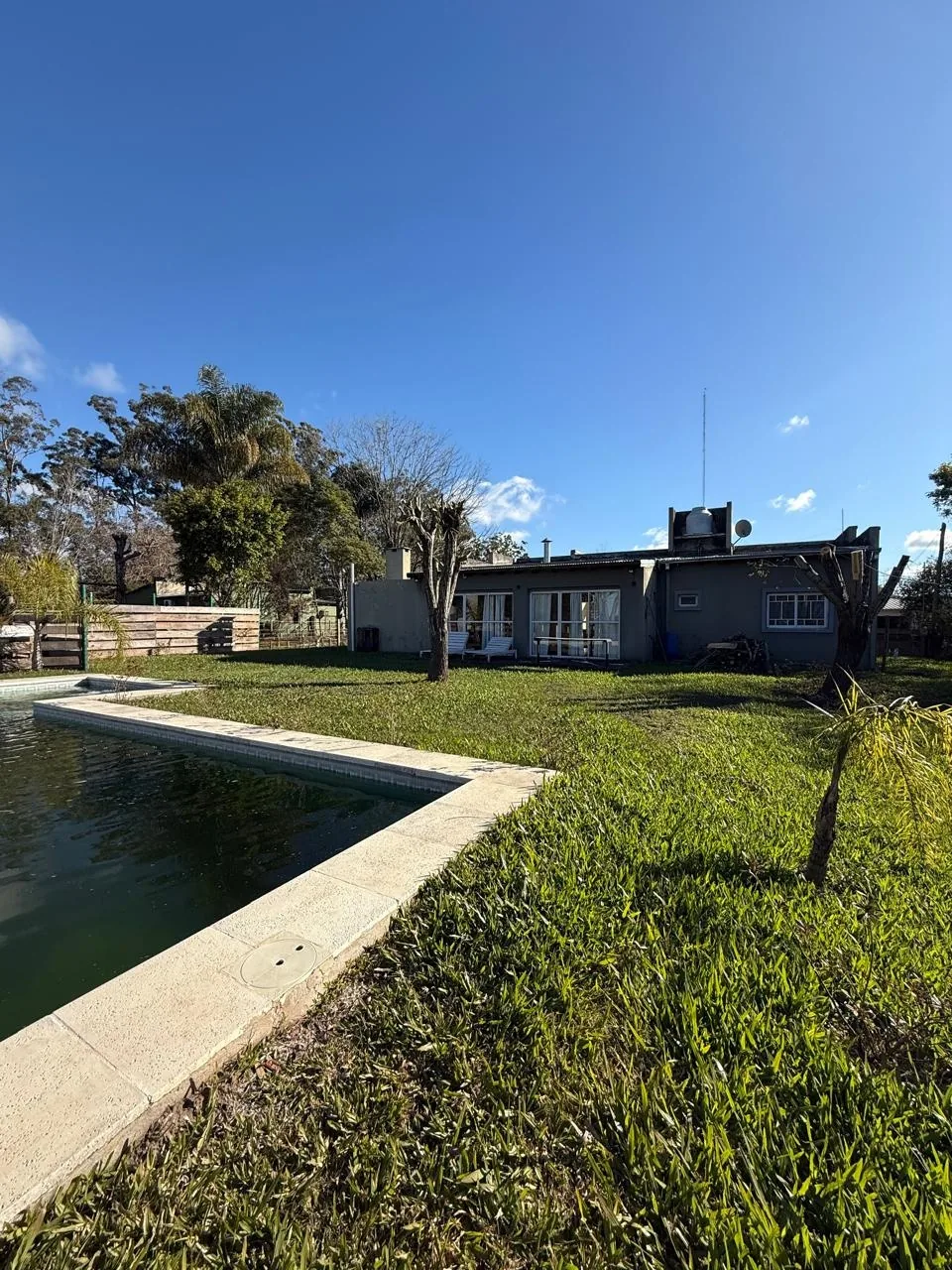 El patio trasero, con la piscina y la casa al fondo