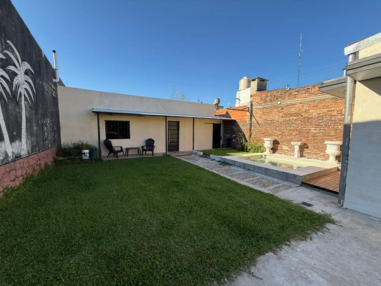 Patio con césped y galería de Coldaroli 186