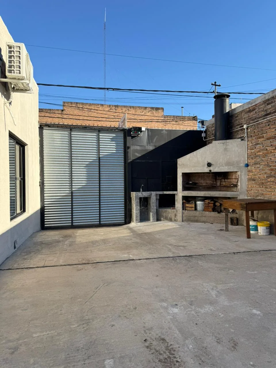 Patio de ingreso, con portón y parrilla