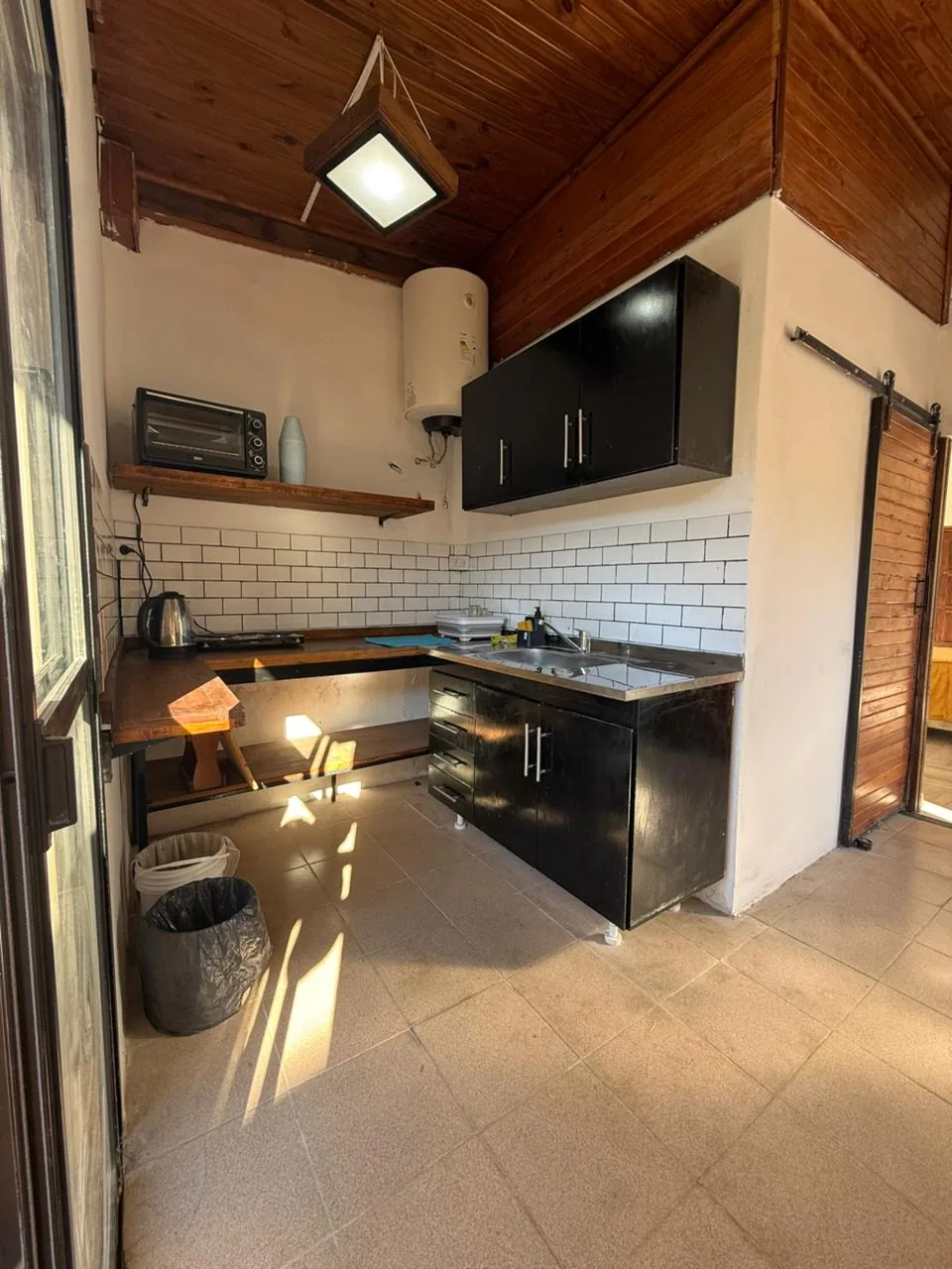 Cocina con bajo mesada, alacenas y termotanque