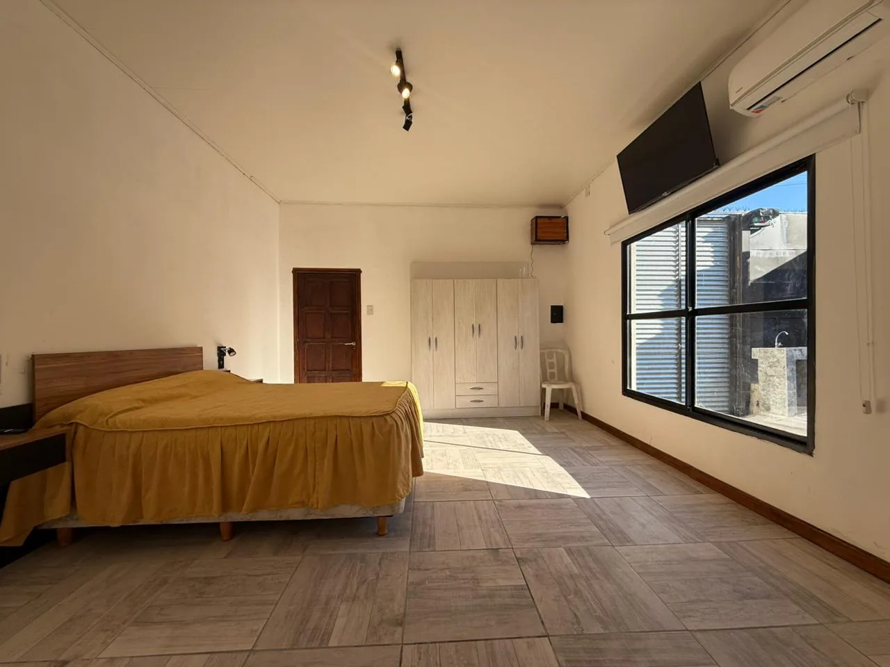 Dormitorio con cama doble, placard, aire acondicionado y TV