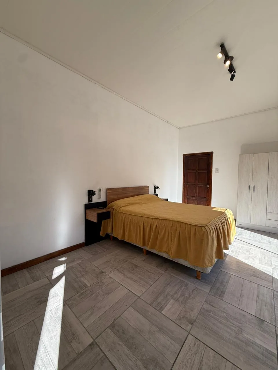 El dormitorio, con mesa de luz y placard