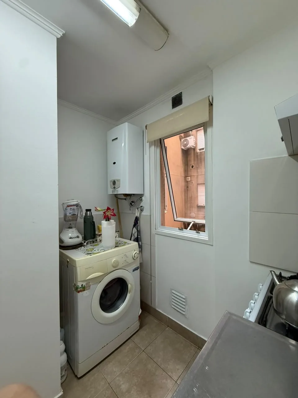 El sector de lavadero dentro de la cocina, con lugar para el lavarropas, calefón y ventana