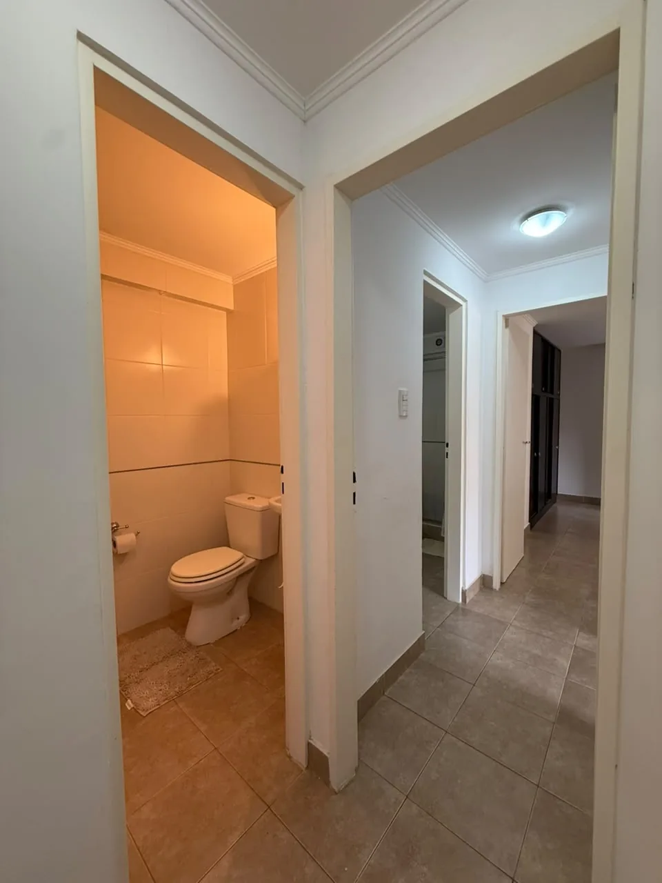 El pasillo hacia los dormitorios, con el toilette a la izquierda y el baño al fondo
