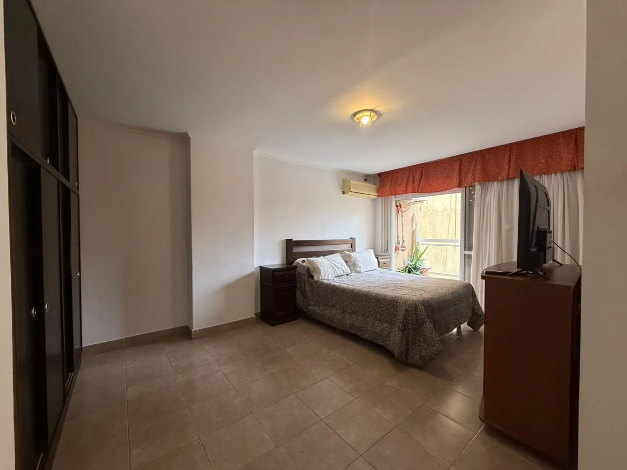 El dormitorio principal, amplio, con placard de piso a techo y salida al balcón
