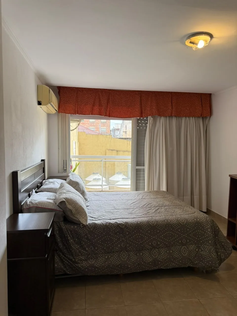 Hacia el balcón, con puerta ventana con persiana y aire acondicionado split