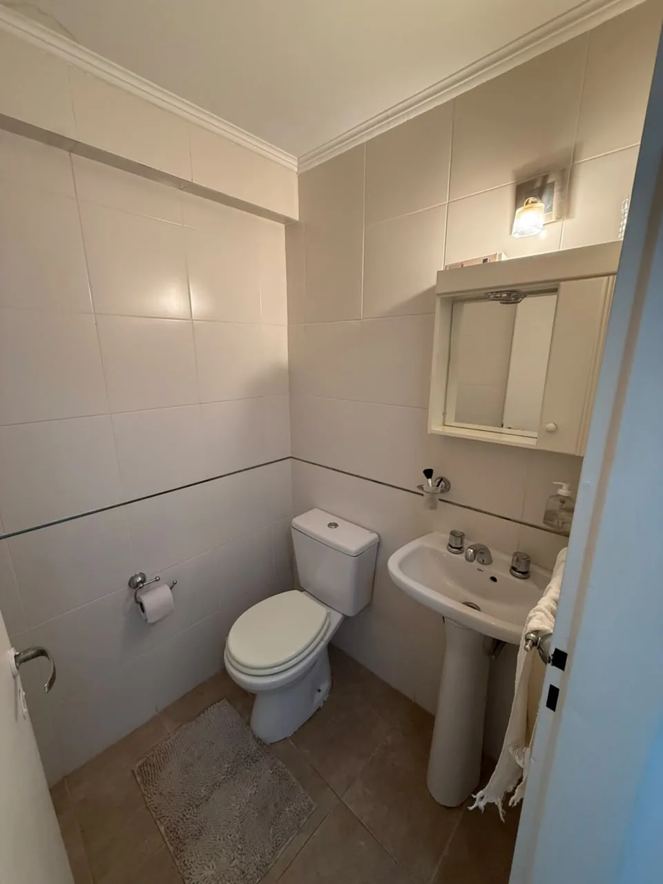 El toilette, con inodoro, lavatorio de pie y botiquín con espejo