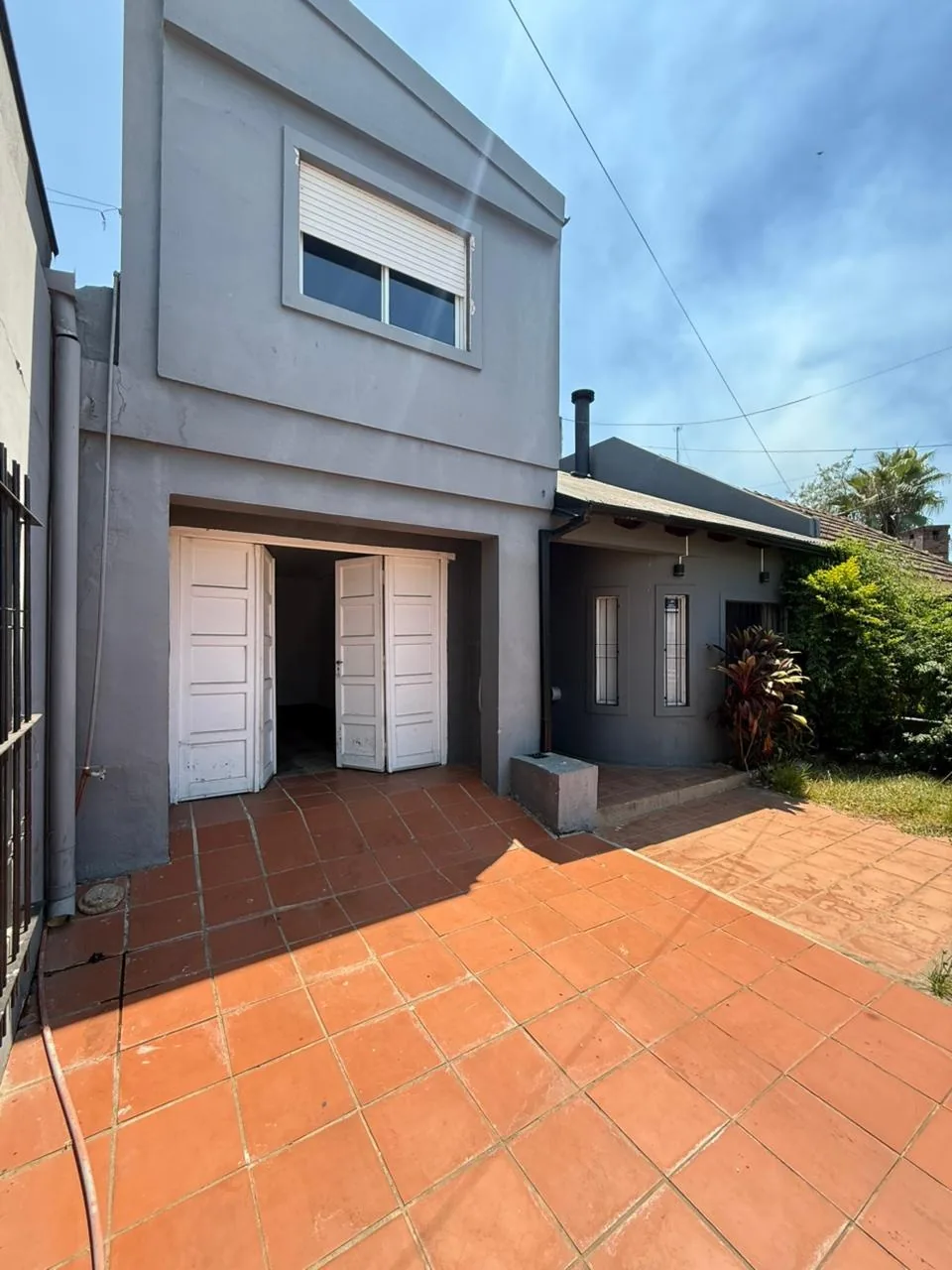 La casa desde el patio de entrada, con el garage cubierto y la galería