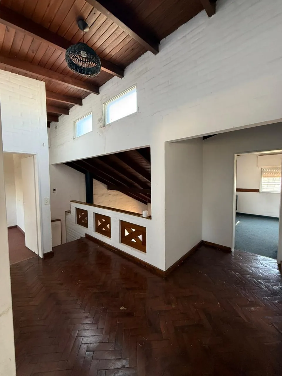 El palier de la planta alta, con piso de parquet y techo de madera