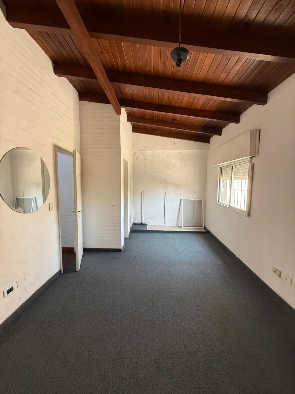 Dormitorio de planta alta, alfombrado y con techo de madera
