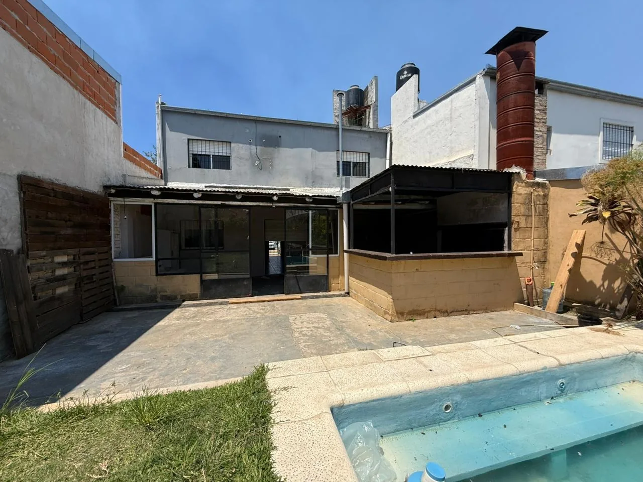 El fondo de la casa: galería cerrada y quincho con parrilla, junto a la pileta
