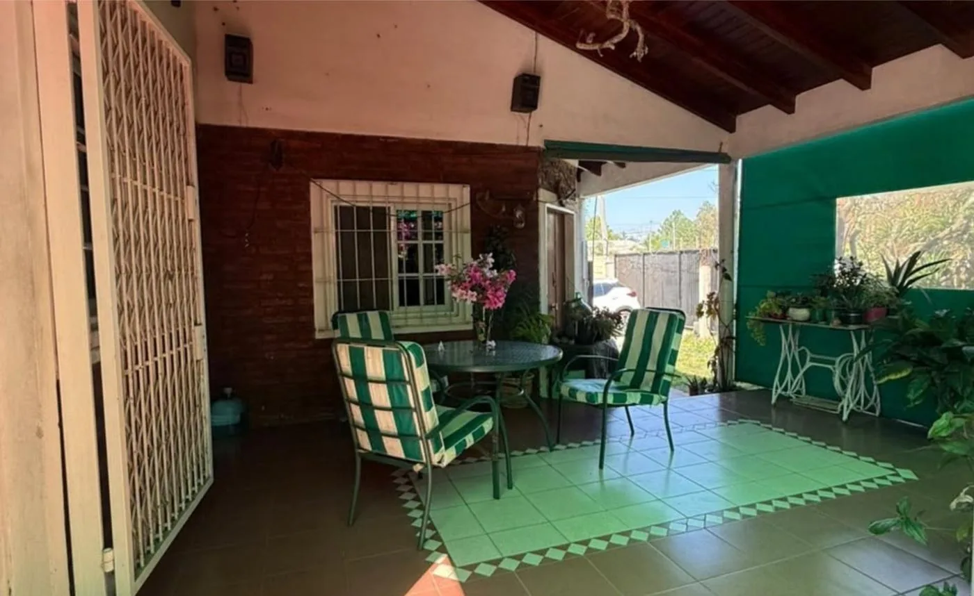 La galería, con la mesa de afuera y la puerta de entrada a la casa