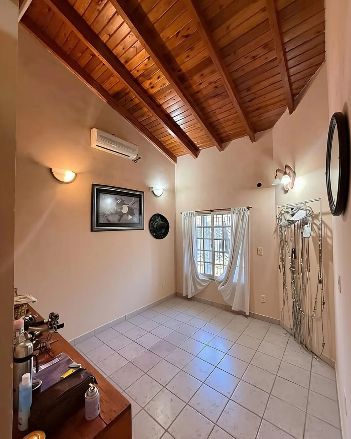 La sala de estar al ingreso, con techo de madera y aire acondicionado: ideal como escritorio u oficina