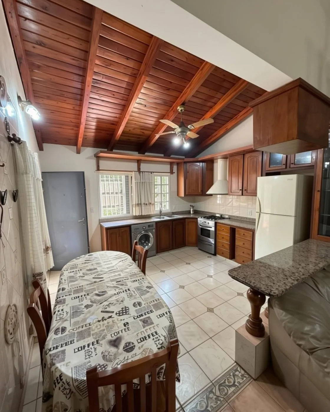 Cocina y comedor integrados, con techo de madera a dos aguas
