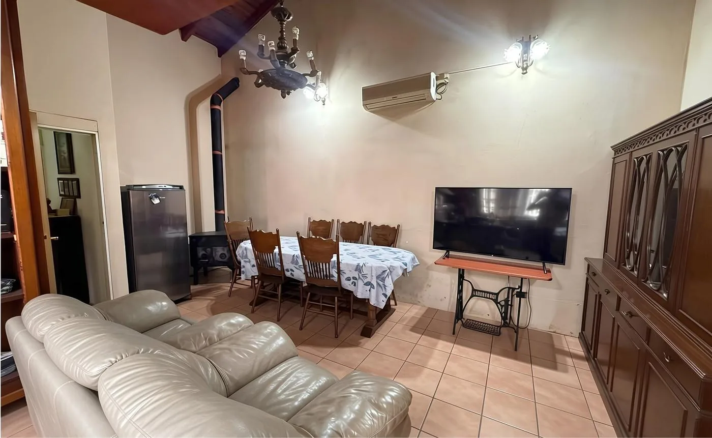 Living con sillones de cuero, mesa para ocho y estufa a leña