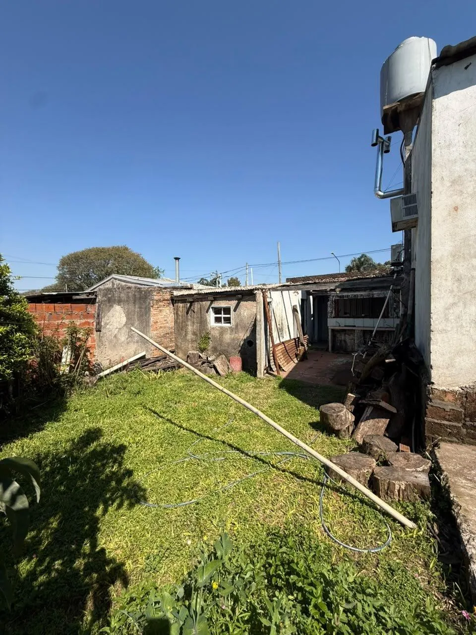 El fondo del lote, con césped, y la segunda construcción a reciclar