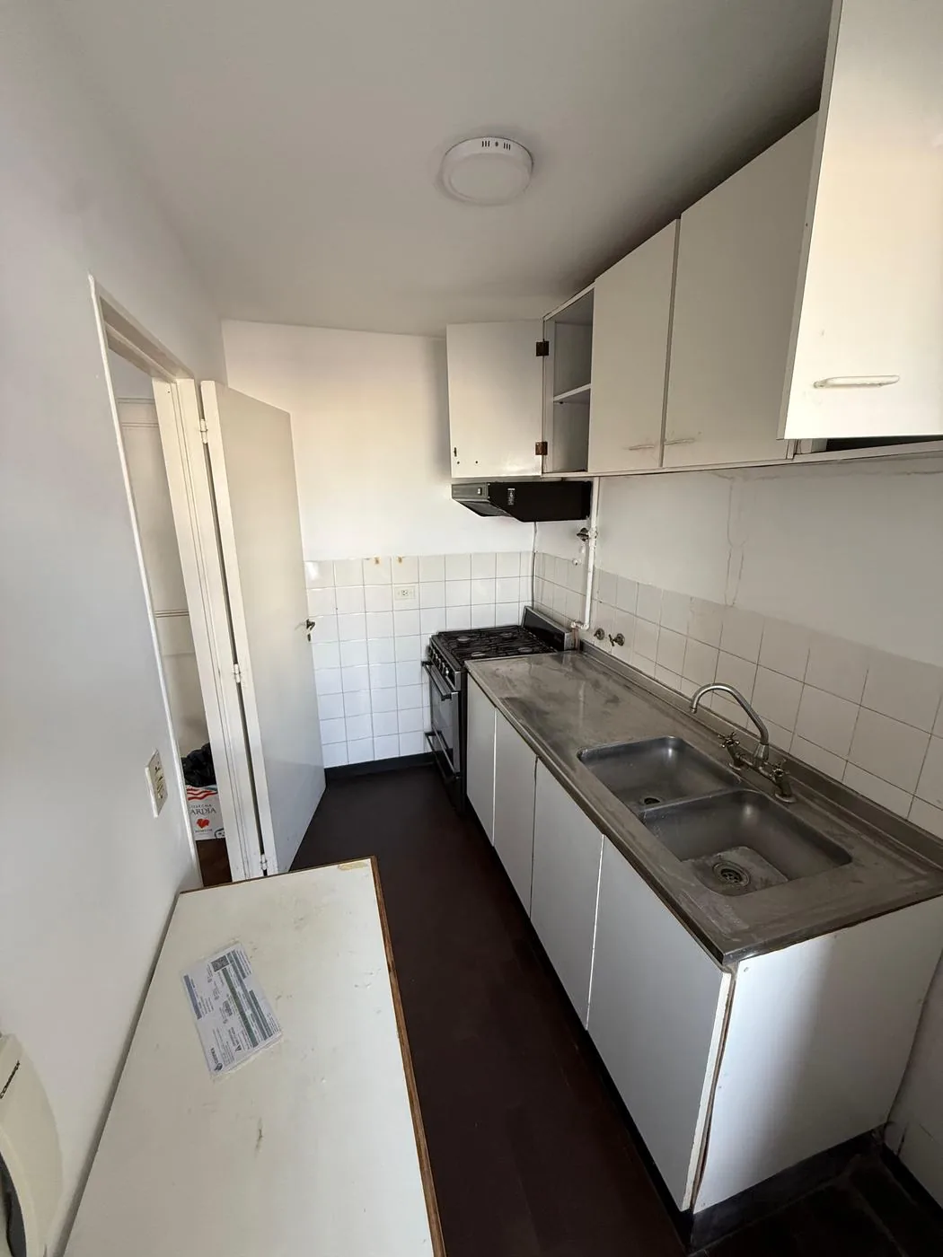 Cocina completa, con muebles bajo y sobre mesada, bacha doble de acero y campana