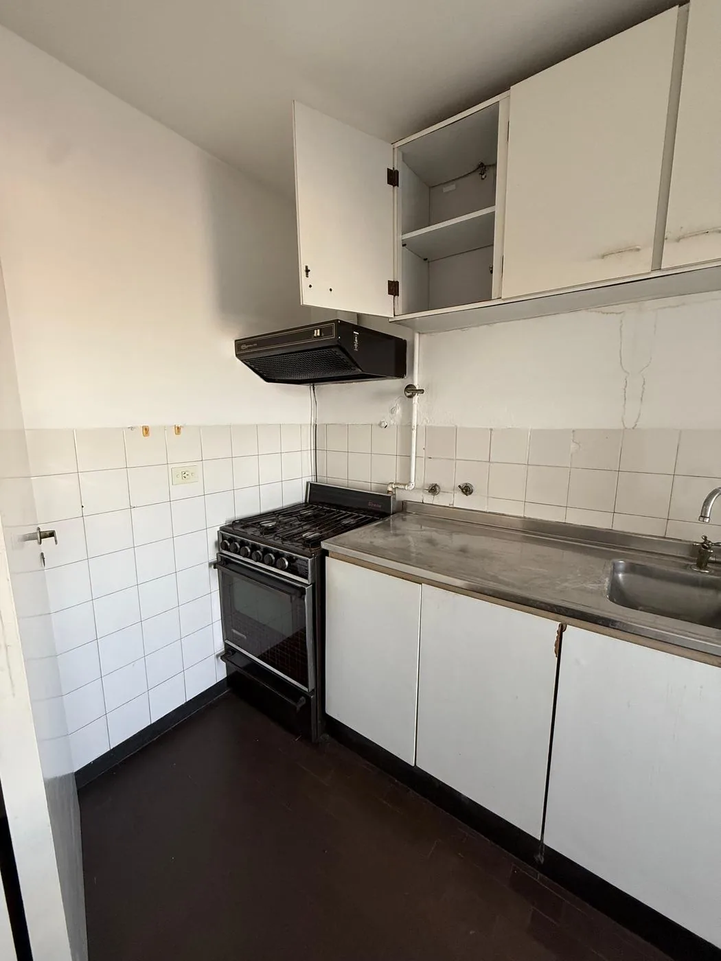 Cocina con horno, alacenas y mesada de acero inoxidable