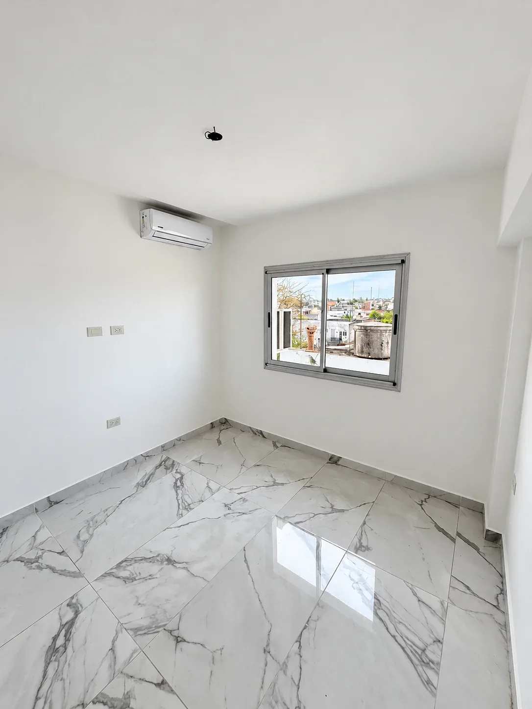 El dormitorio, con piso símil mármol