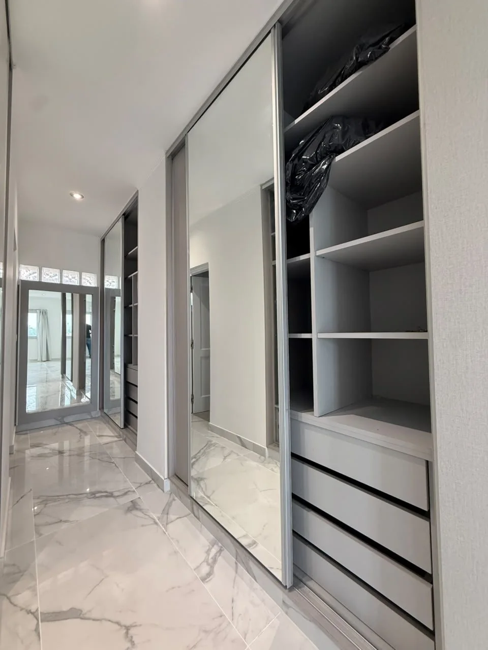 El vestidor, con placares de puertas espejadas a ambos lados