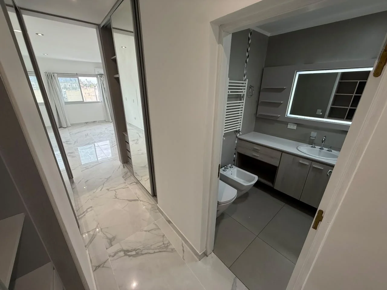 Del vestidor al baño de la suite, con piso símil mármol