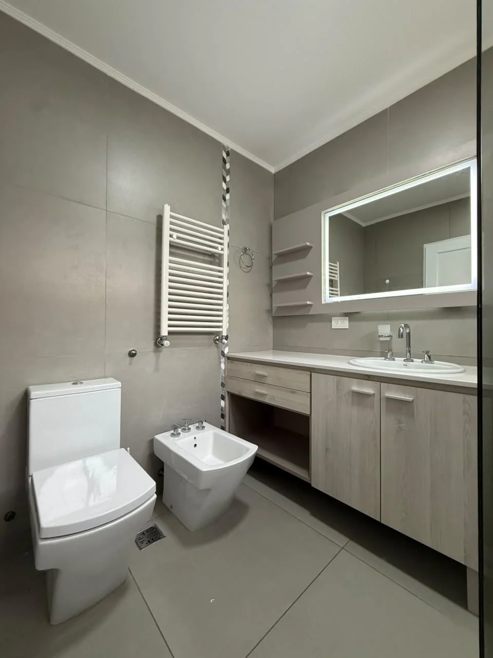 El baño de la suite, con estantes junto al espejo iluminado