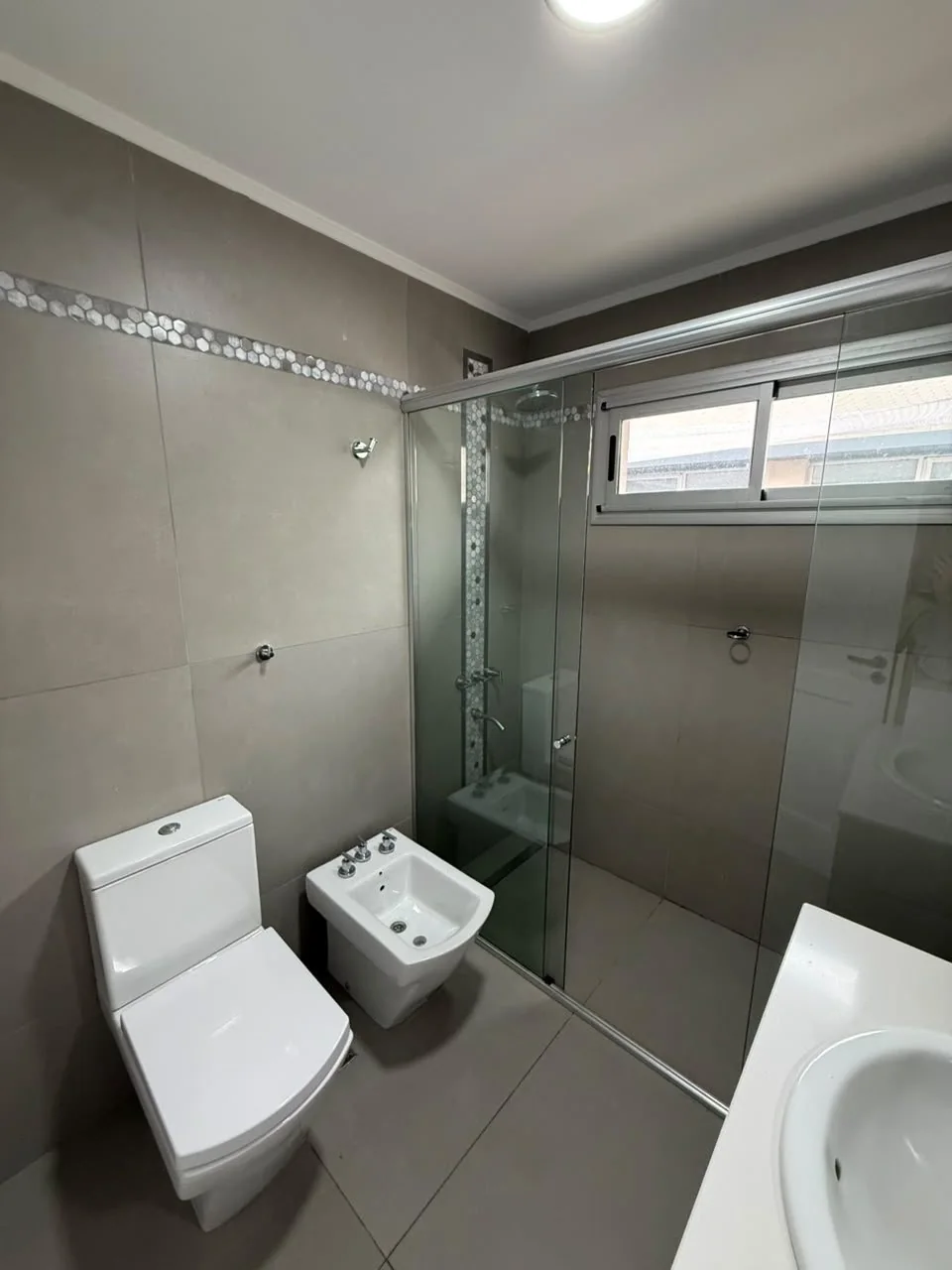 El mismo baño, con guarda de mosaicos y ventana