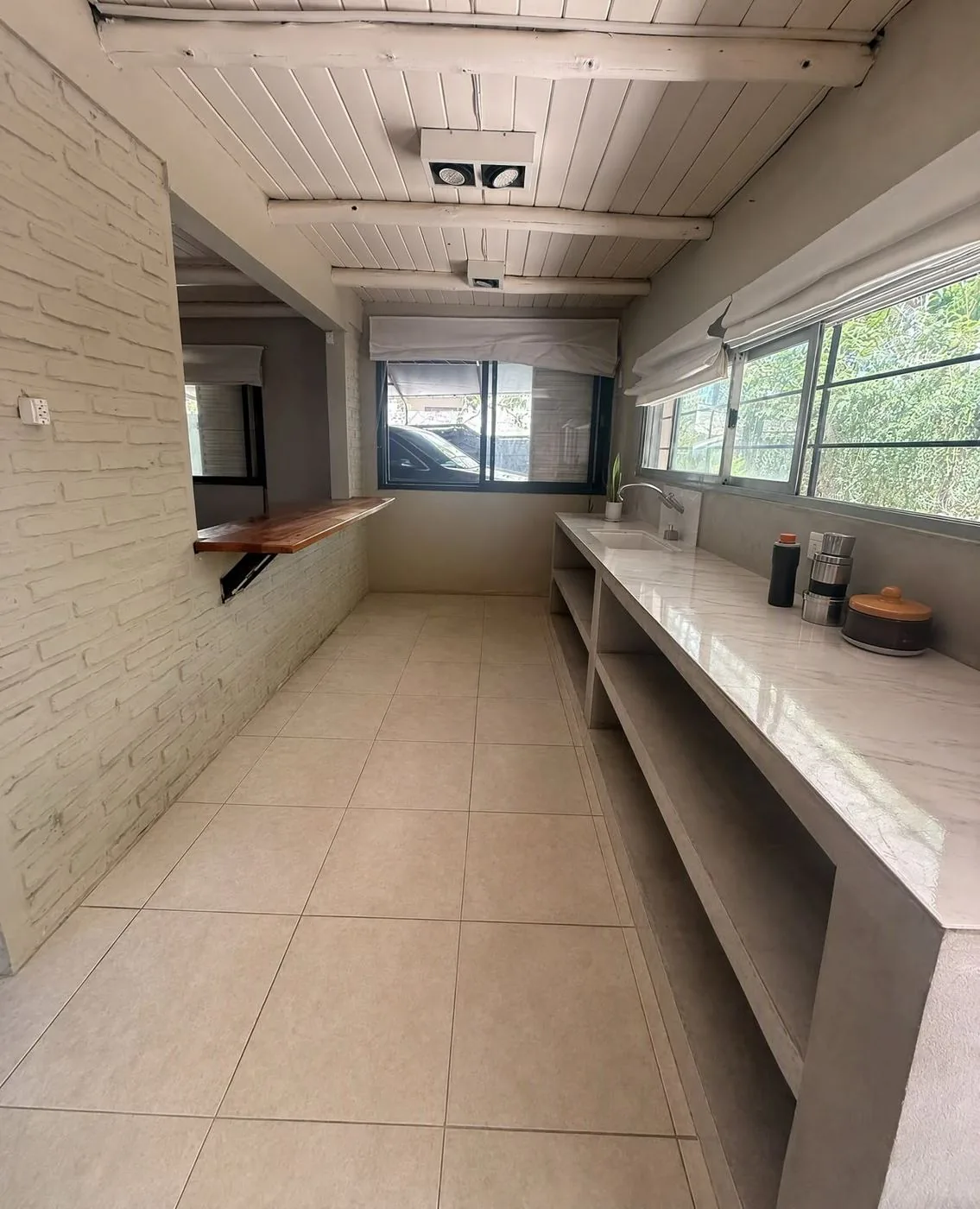 La cocina, funcional, con mesada larga, pasaplatos al comedor y ventanas al jardín
