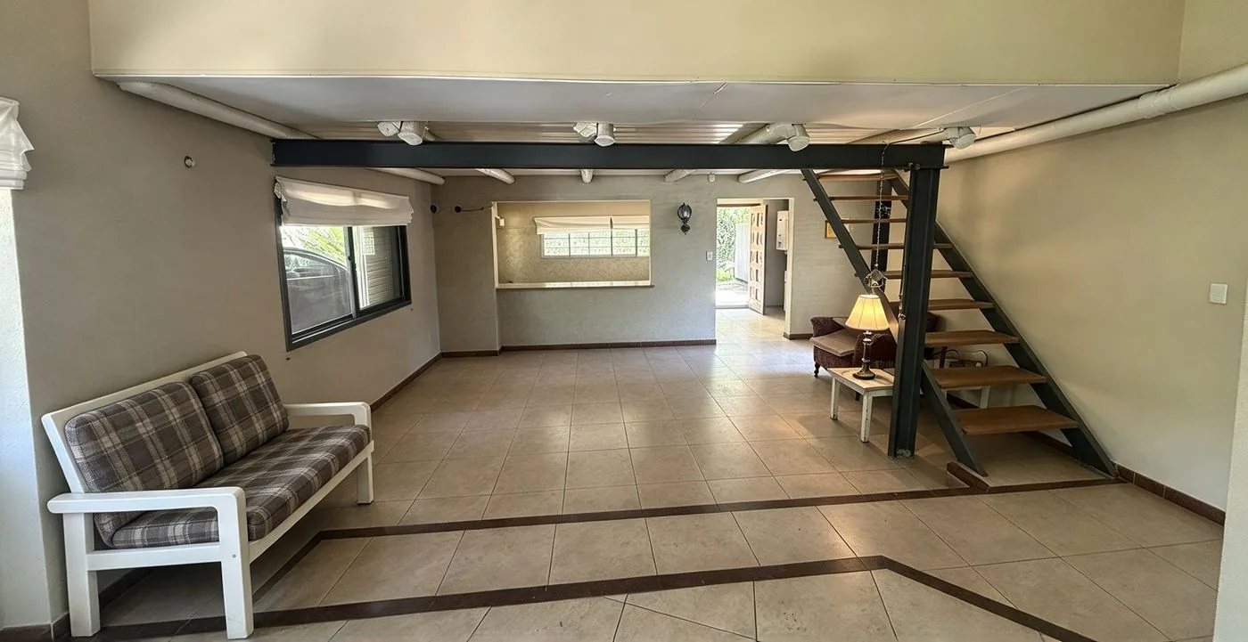 El comedor, con el pasaplatos a la cocina y la escalera de madera y hierro a la planta alta