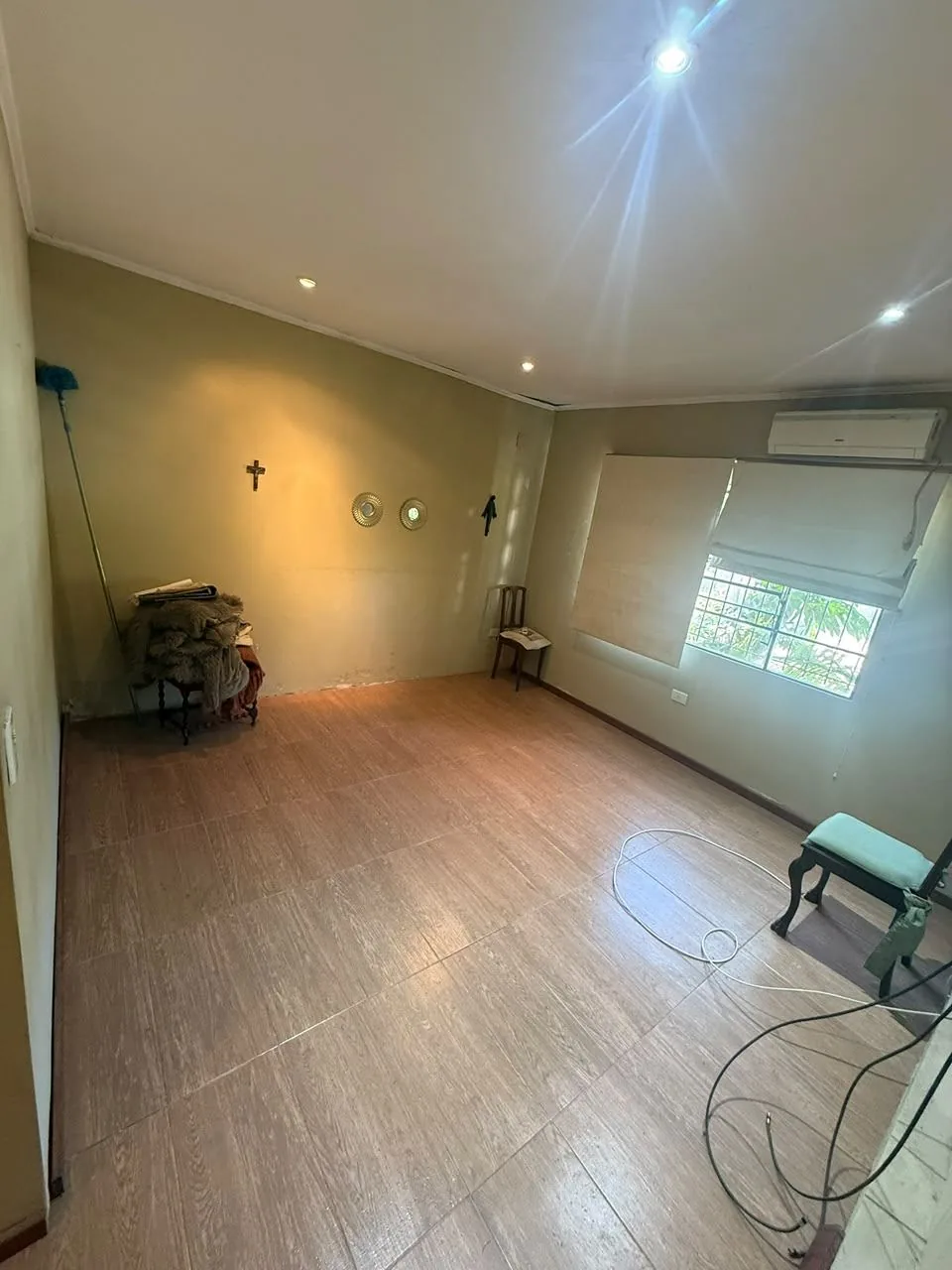 Dormitorio de planta baja, con aire acondicionado, ventana con cortina roller y piso símil madera