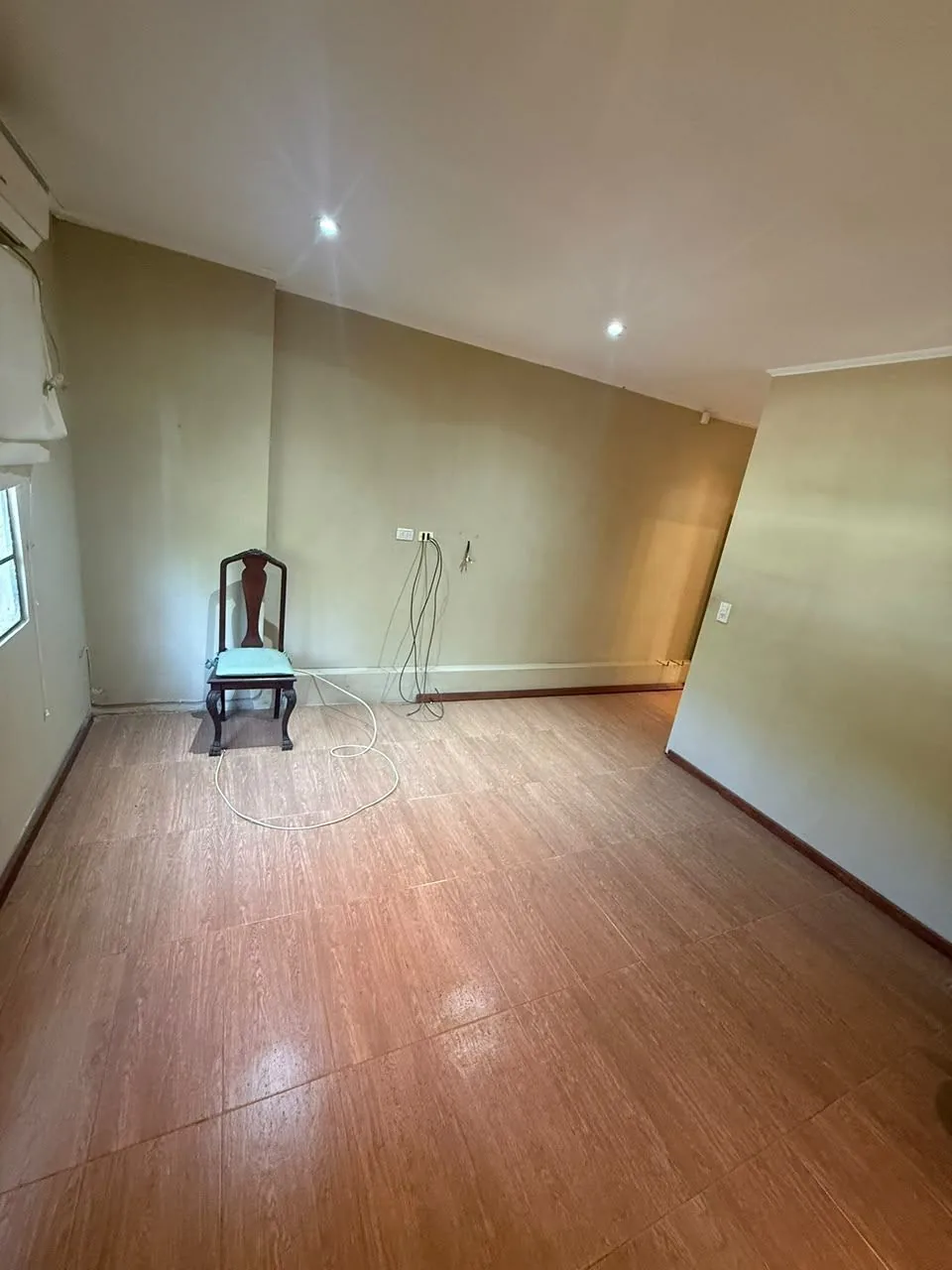 El mismo dormitorio desde el otro lado, con ventana y piso símil madera