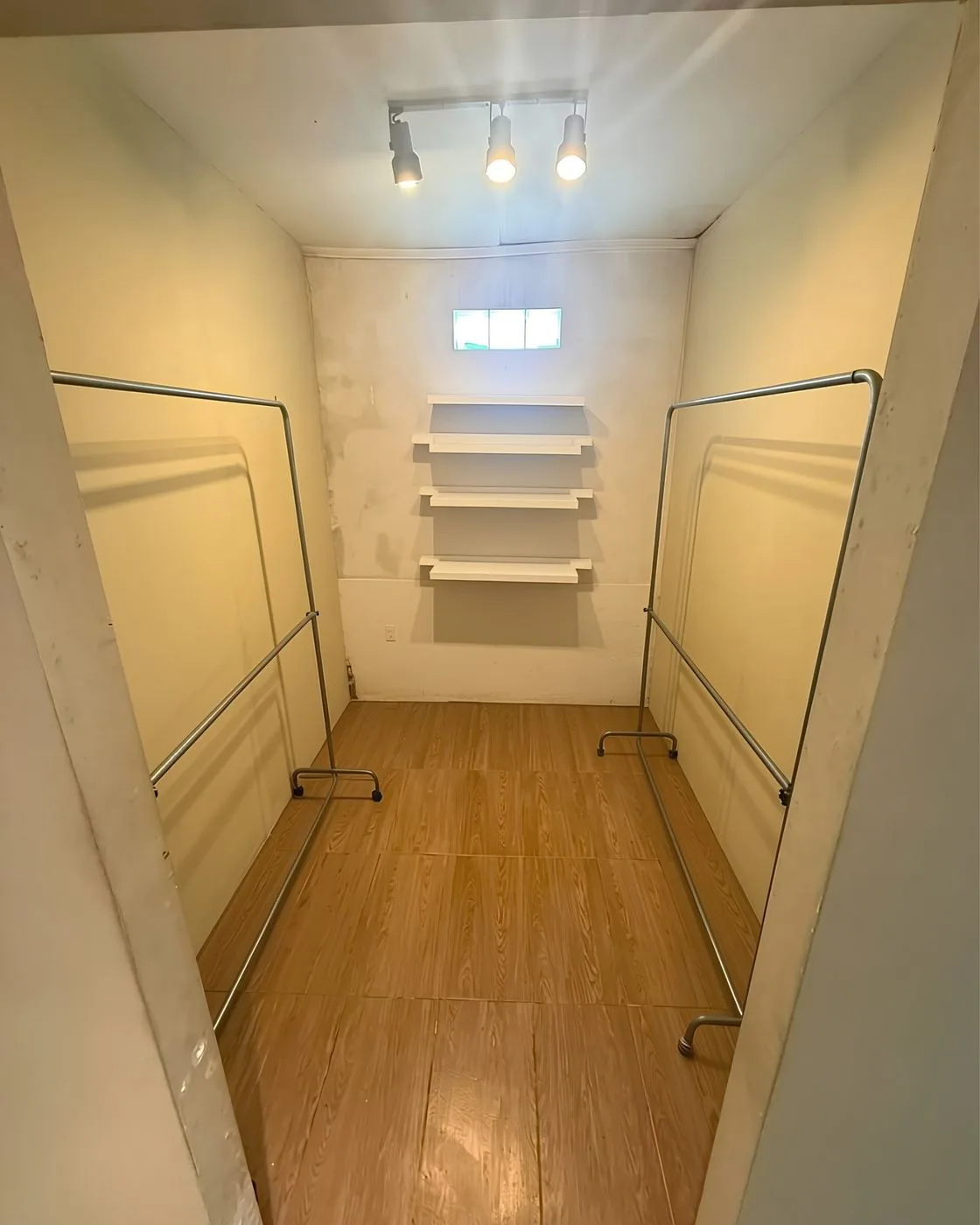 El vestidor, con percheros a ambos lados, estantes y ventana alta