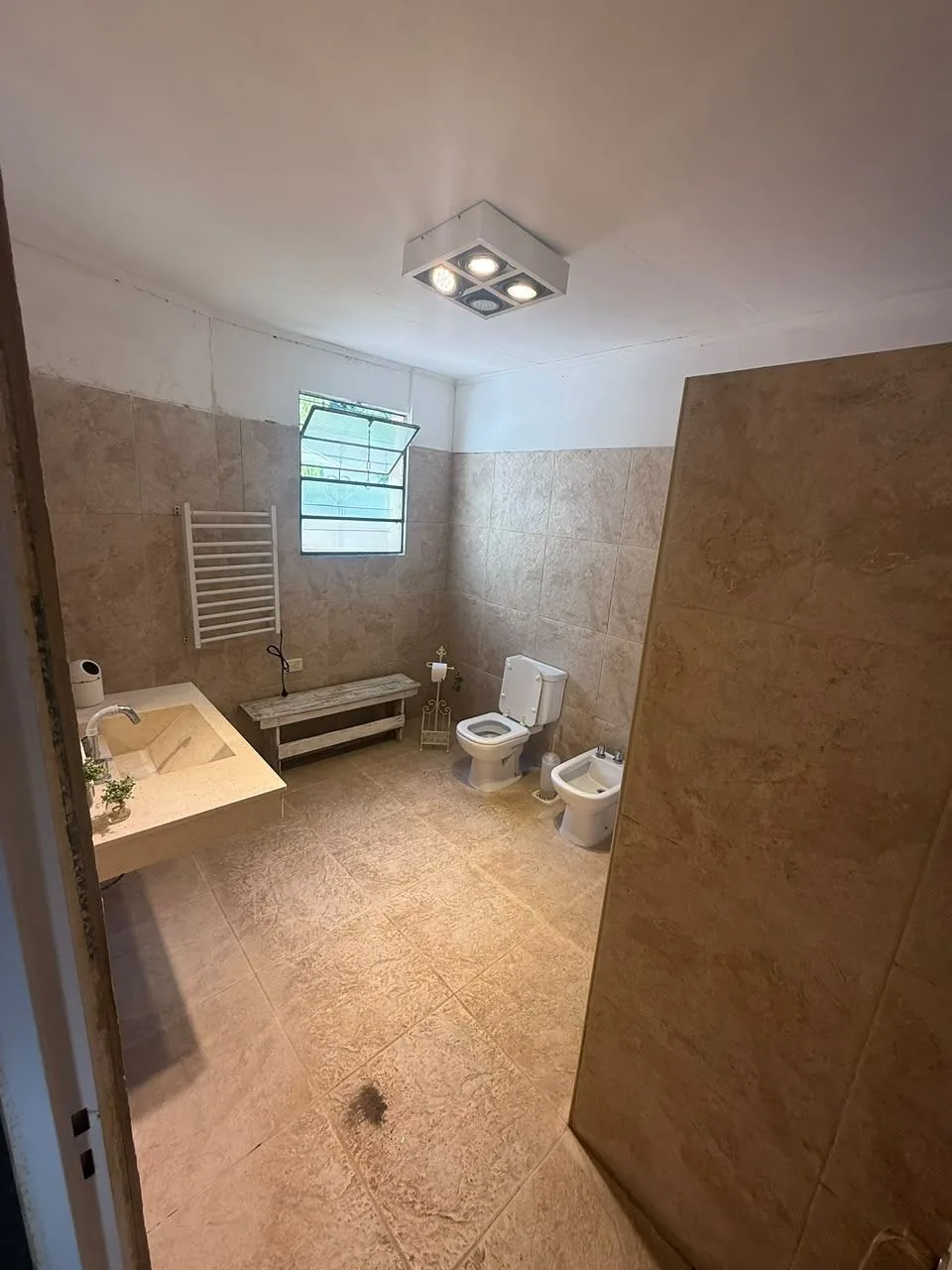 Baño amplio, con bacha de mármol, ducha con separador, bidet, toallero y ventana