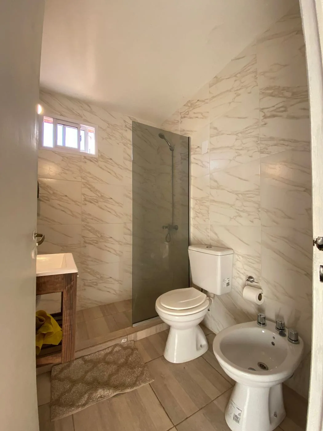 Baño completo, renovado: ducha con mampara de vidrio, inodoro, bidet y vanitory de madera