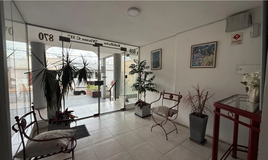 Hall de ingreso con puerta de vidrio, portero y sala de espera