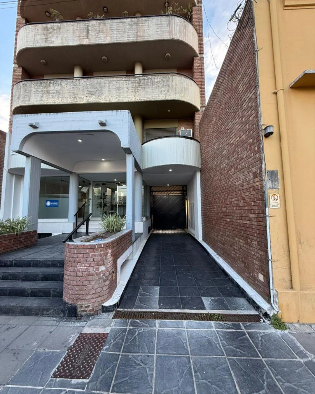 La entrada al garage cubierto, con portón automatizado, al lado del hall