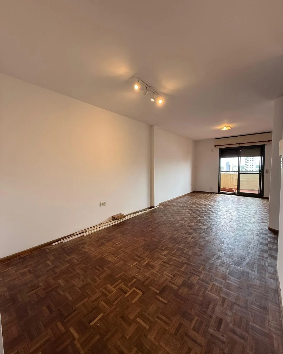 El largo del living, con spots y salida al balcón al fondo