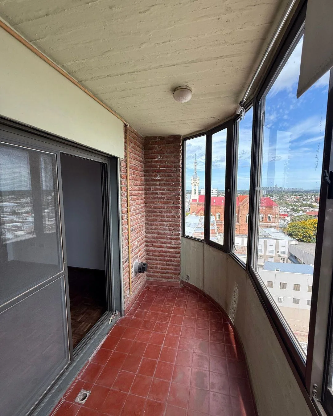 El extremo del balcón, cerrado con ventanas, con la catedral y el centro a la vista