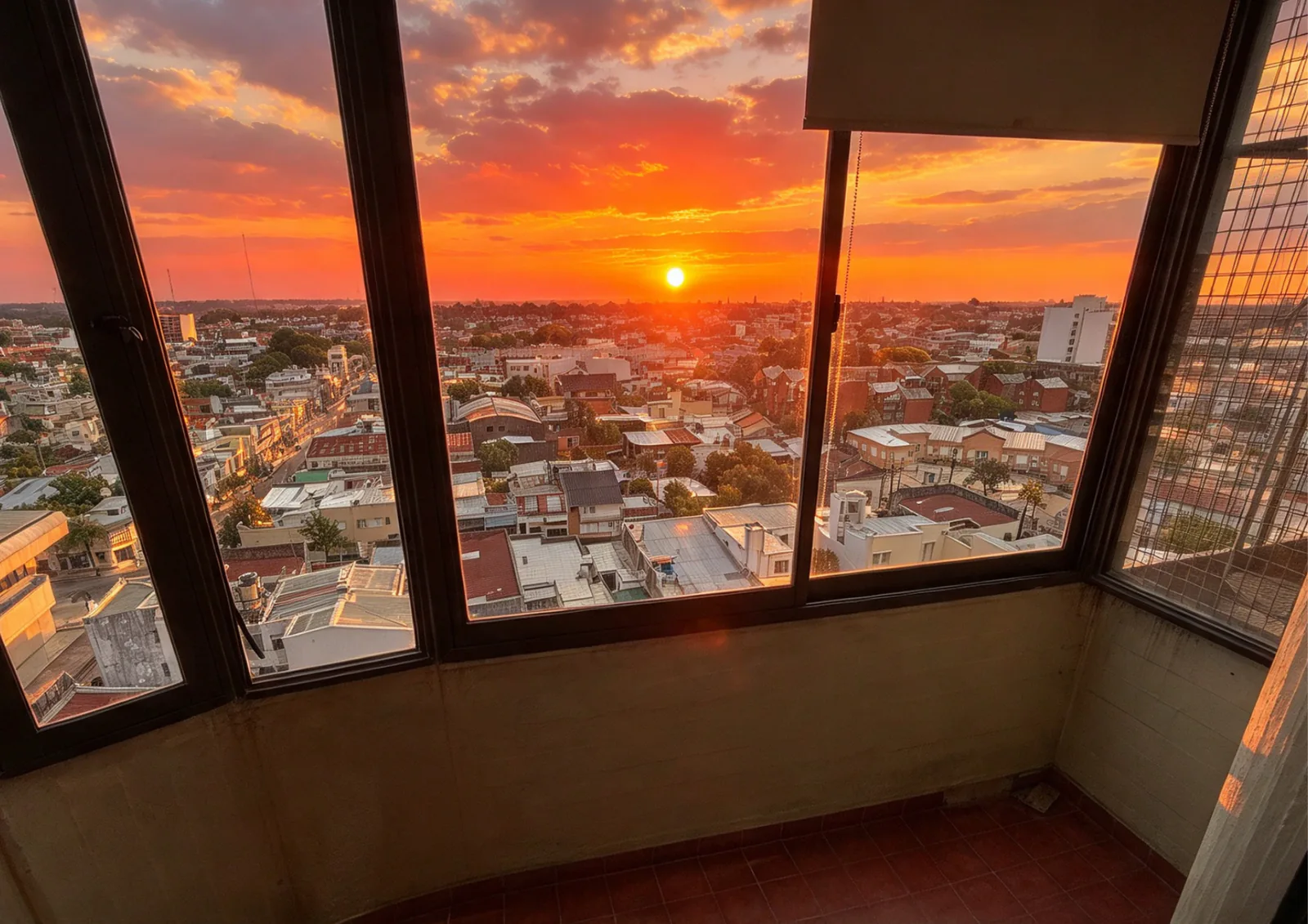 El atardecer desde el extremo cerrado del balcón, con la ciudad hasta el horizonte