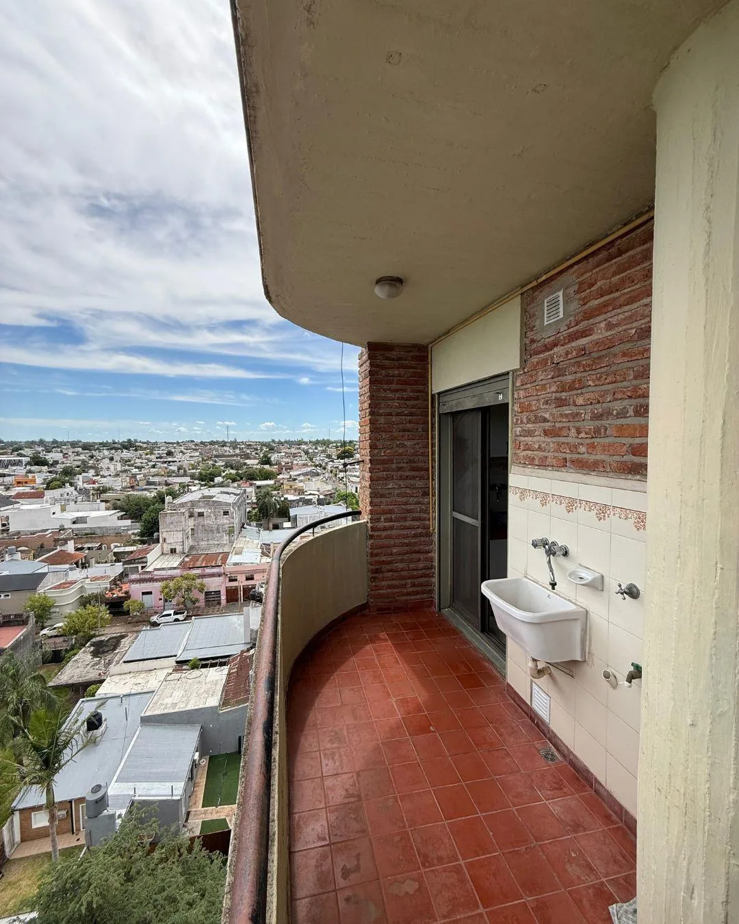 El lavadero, en el balcón de servicio junto a la cocina, con pileta y vista abierta