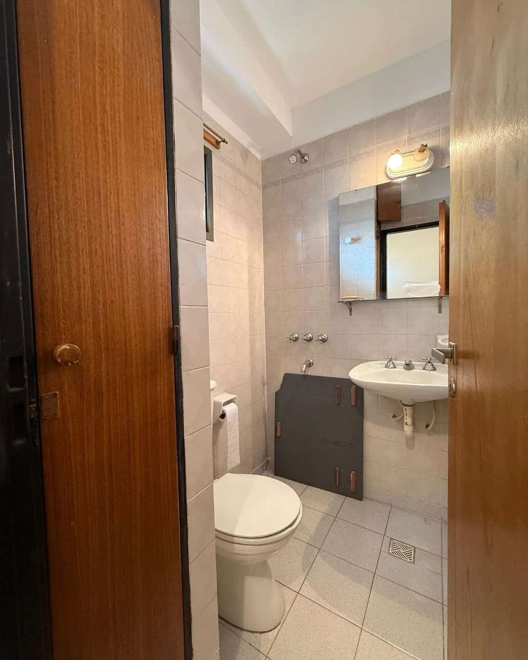 Baño de servicio junto a la cocina, con ducha, lavatorio e inodoro
