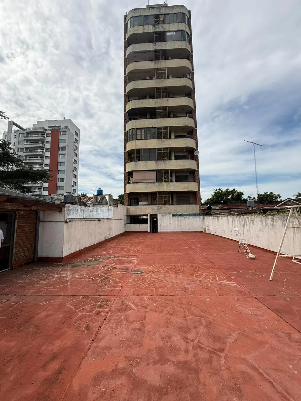 El playón trasero: un espacio amplio que se puede usar para distintos fines, cerca del quincho / SUM, con la torre de fondo