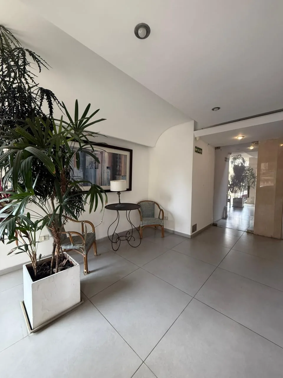 El hall de entrada, con plantas, sector de espera y paso hacia los ascensores