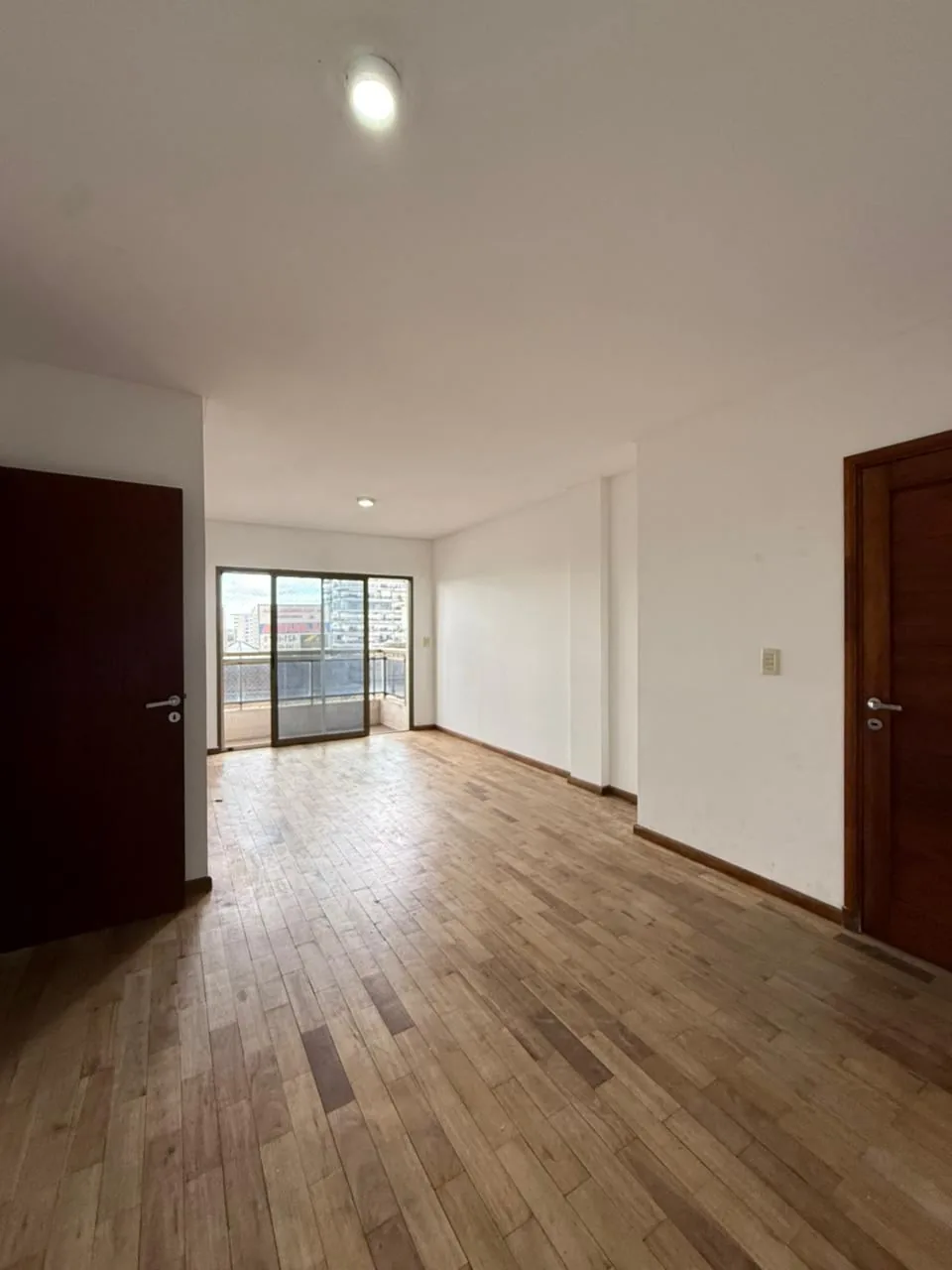 Living comedor de Urquiza y Catamarca, con piso de madera y salida al balcón