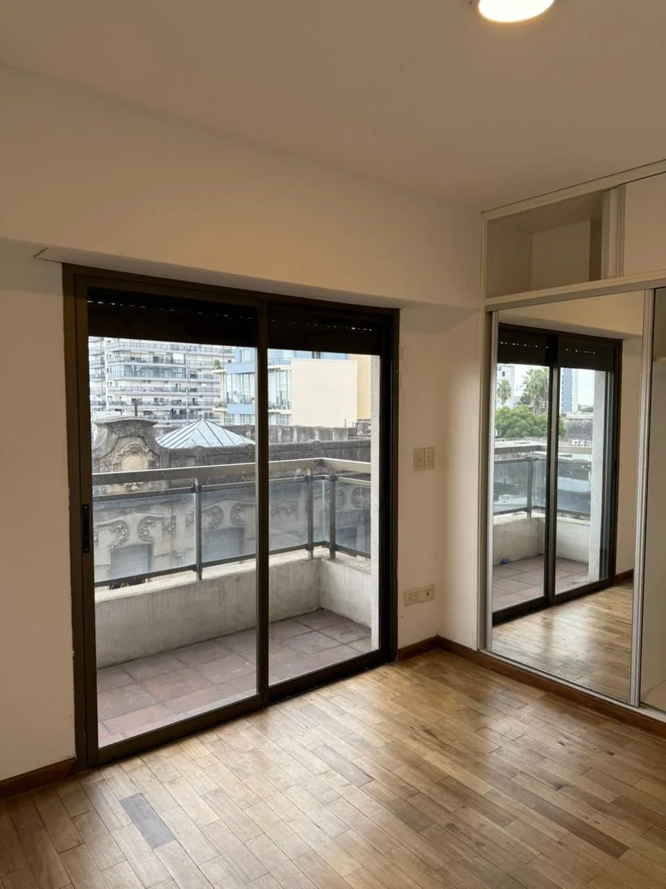 El segundo dormitorio hacia el balcón, con el placard de puertas espejadas